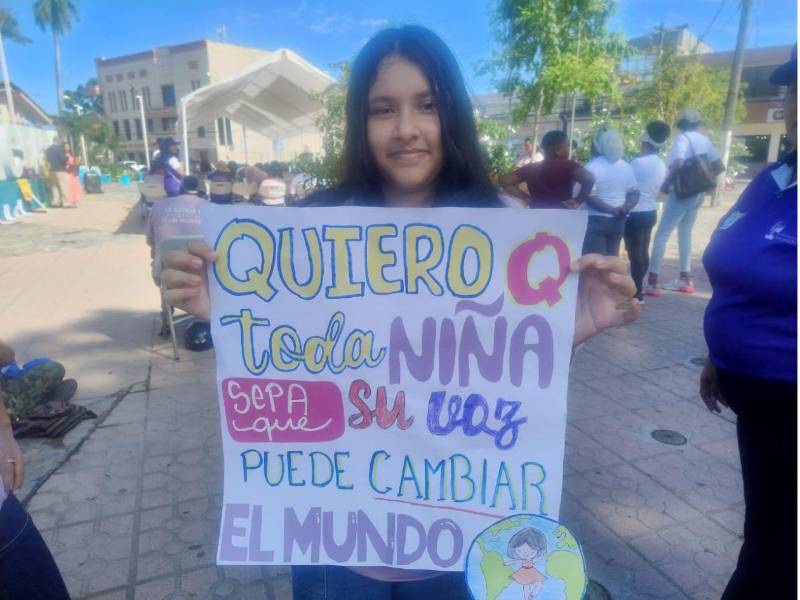 Joven con una pancarta exigiendo un alto a la violencia.