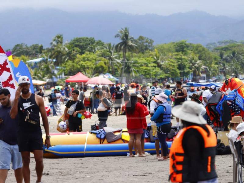 Familias se instalan desde temprano en la arena para compartir y disfrutar del ambiente playero en Puerto Cortés.