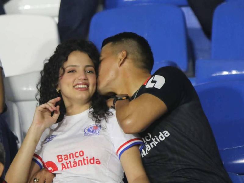 Viva el amor. Pareja de olimpistas en el sector de silla del estadio Nacional listos para ver al León.