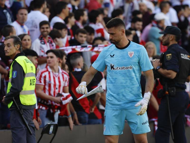 El portero del Athletic de Bilbao, Unai Simón retira uno de los aviones de papel con mensajes contra la gestión de Martín Presa que fueron lanzados en el minuto 13 por la afición del Rayo Vallecano.