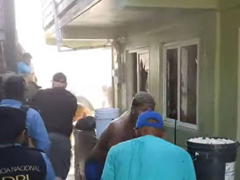 Pobladores sofocan las llamas del incendio en la escuela Cristóbal Colón.