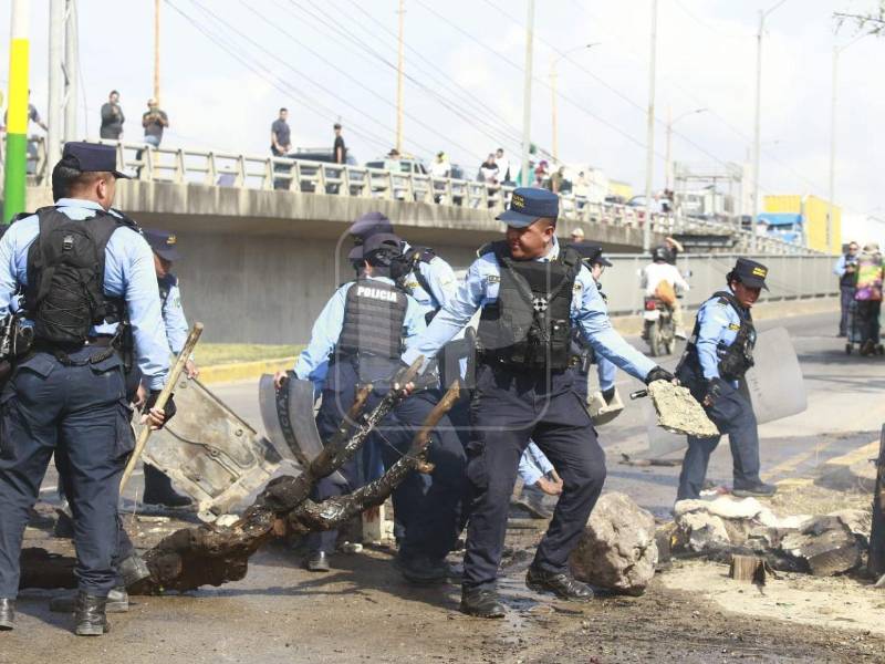 Agentes policiales desalojaron a manifestantes que bloquearon este viernes ambas trochas del puente <b>La Democracia, en El Progreso</b>, Yoro, tras protestas contra el aumento a la tasa vehicular municipal.