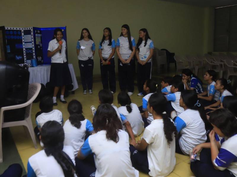 Un grupo de estudiantes de octavo grado de la María Mazzarello realizando una presentación de su proyecto a otros alumnos de la institución.