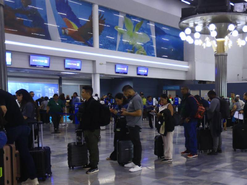 Pasajeros se forma en fila para hacer el proceso de Check-in en el aeropuerto Ramón Villeda Morales.