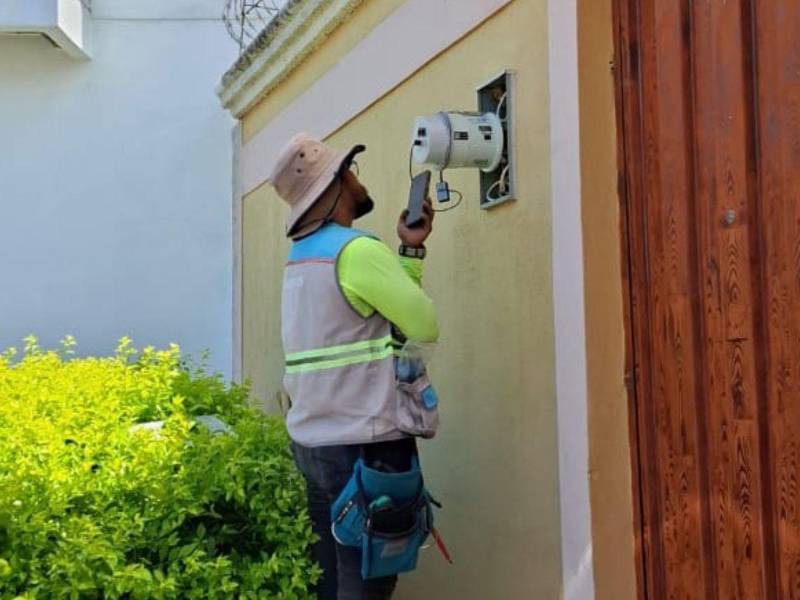 Empleado del Programa Nacional para la Reducción de Pérdidas (PNRP) realizando la revisión de un medidor.