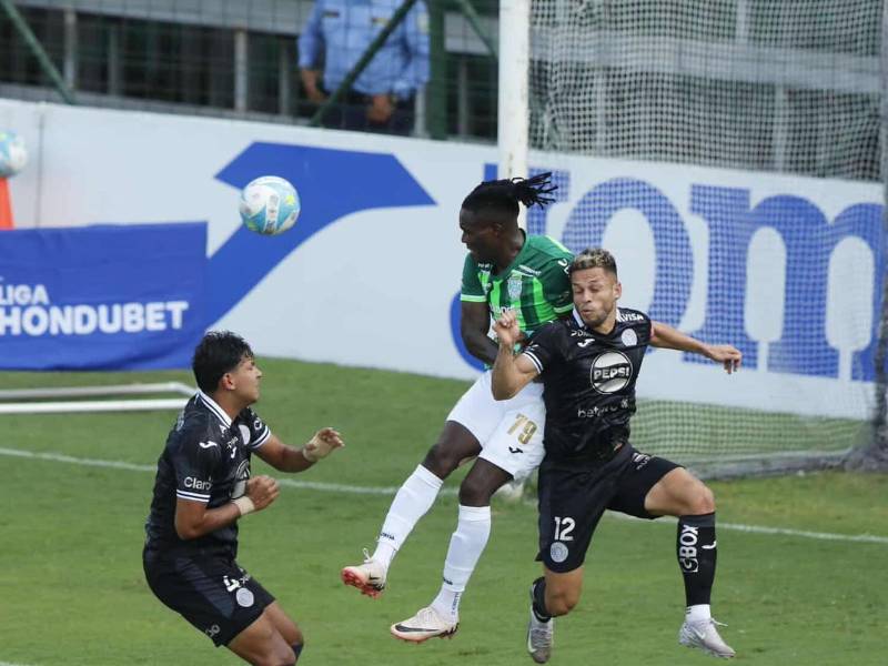 Rubilio Castillo saltando por el balón con Marcelo Santos.