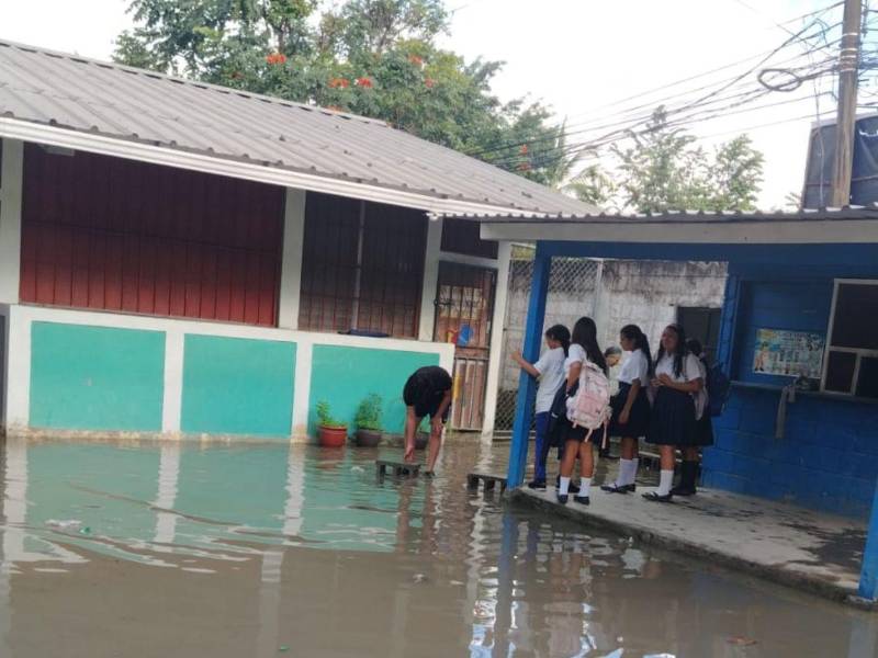 Una madre coloca bloques para que los estudiantes del centro puedan ingresar a sus aulas.