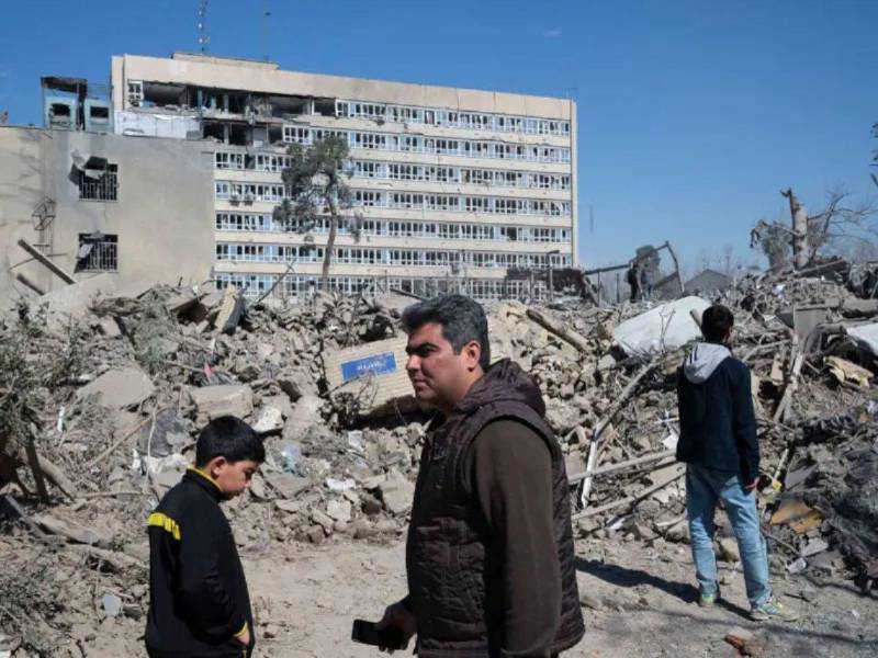 Varias personas caminan cerca de una zona alcanzada por los bombardeos israelíes-estadounidenses en los alrededores del Gran bazar de Teherán.