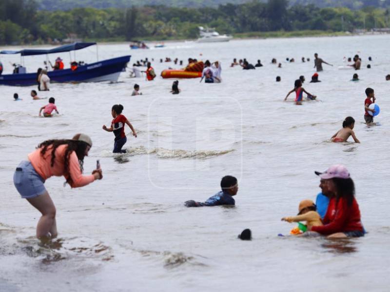 Decenas de personas ingresan al mar pese a las condiciones del agua, disfrutando del calor y la jornada recreativa.