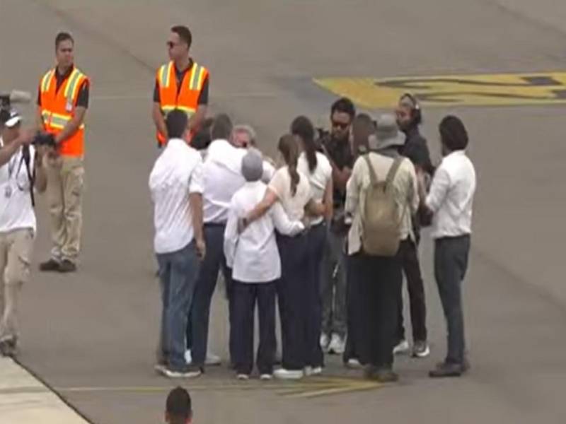 El expresidente Juan Orlando Hernández se abraza con su esposa Ana García, sus hijas y familiares más cercanos tras descender de la aeronave en la pista del Aeropuerto Internacional de Palmerola.