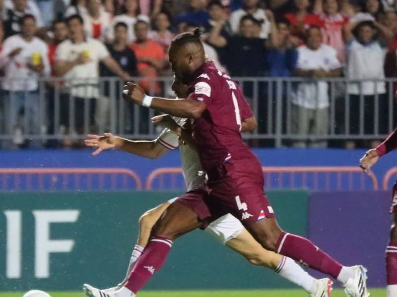 Kendall Waston del Saprissa en la disputa del balón con el delantero Imanol Enríquez de Olimpia.