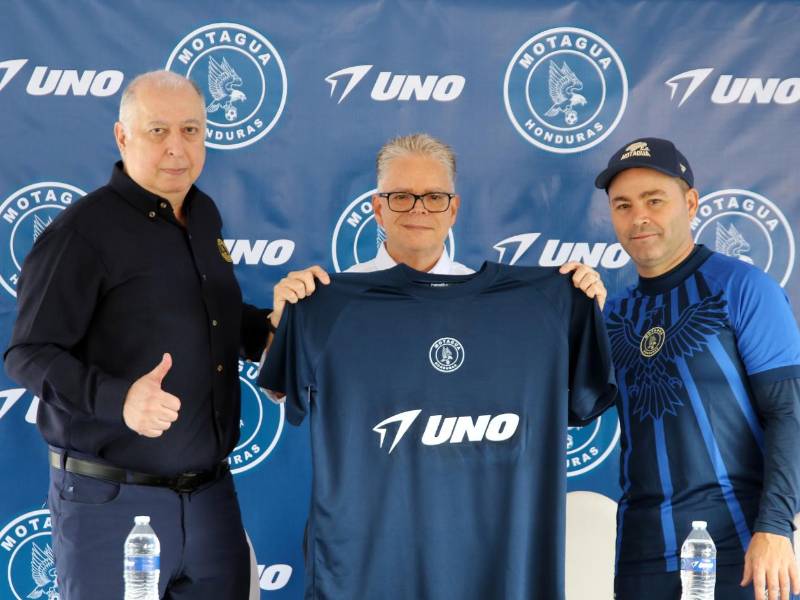 El presidente del F.C. Motagua, Eduardo Atala; Oscar Carías, gerente de País de UNO e integrantes del cuerpo técnico posan con la nueva indumentaria del club. El evento sella el patrocinio de la marca en la camiseta del Ciclón Azul.