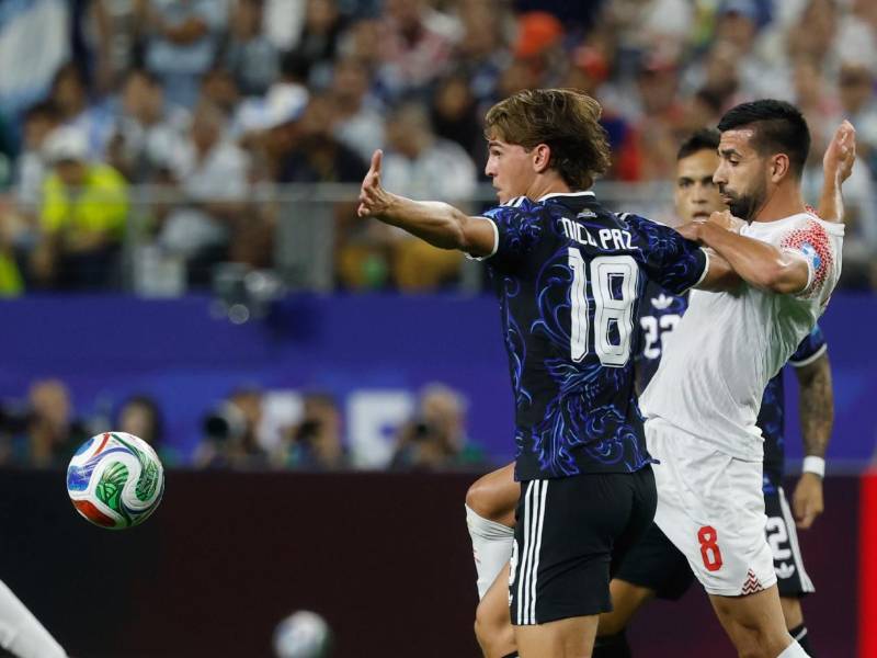 Nico Paz de Argentina disputa el balón con el volante Noor Alrawabdeh de Jordania.