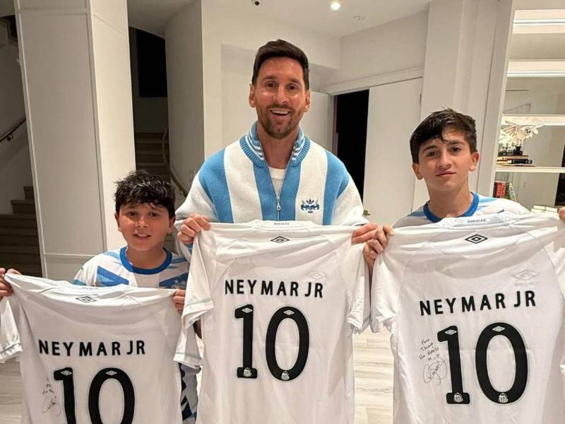 Lionel Messi y sus hijos con la camisa del Santos.