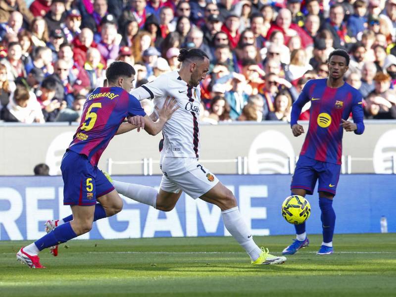 El defensa del Barcelona, Pau Cubarsí (i), presiona al delantero kosovar del Mallorca, Vedat Muriqi.