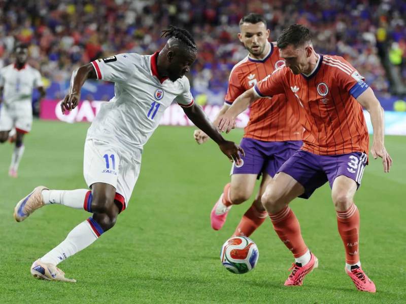 El haitiano Louicius Deedson intenta superar la marca del escocés Andy Robertson.