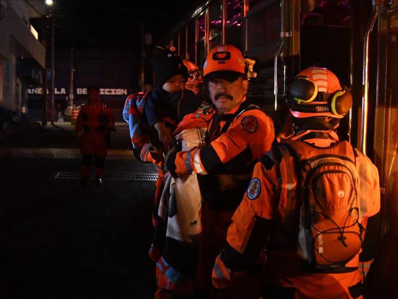 Integrantes de organismos de socorro evacuan a un niño este martes, en Alotenango al suroeste de Ciudad de Guatemala.