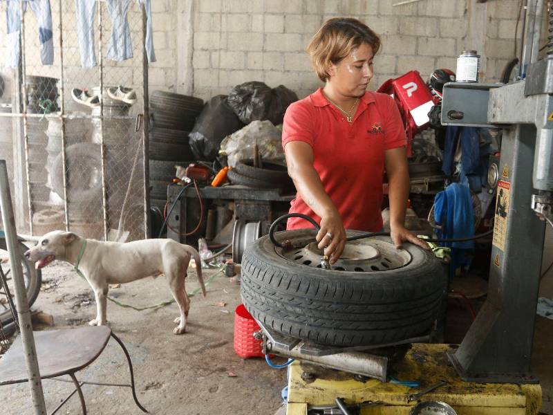 Elizabeth Toro repara llantas de equipo liviano y pesado en el negocio que sus padres abrieron hace unos 30 años en San Pedro Sula.