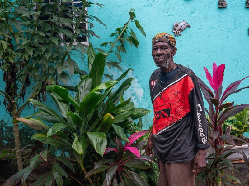 Alfredo Arzú frente a plantas medicinales que sembró en el jardín de unos amigos. A la izquierda, una planta que ayudó durante la pandemia de COVID.