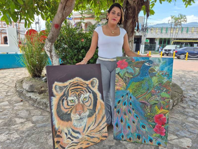 Regina Flores muestra orgullosa las obras originales de su padre Rubén Flores, quien lucha por no perder la vista para seguir con su arte.