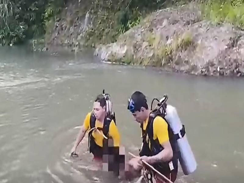 Bomberos rescatan los cadáveres y los llevan a la orilla.