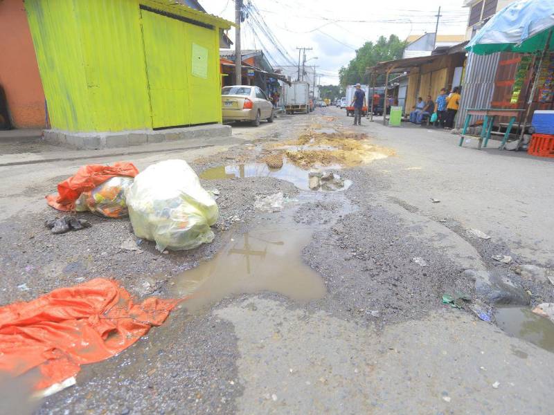 Los ciudadanos que abordan el transporte público deben hacer malabares para esquivar el agua contaminada y no ser salpicados por los automotores.