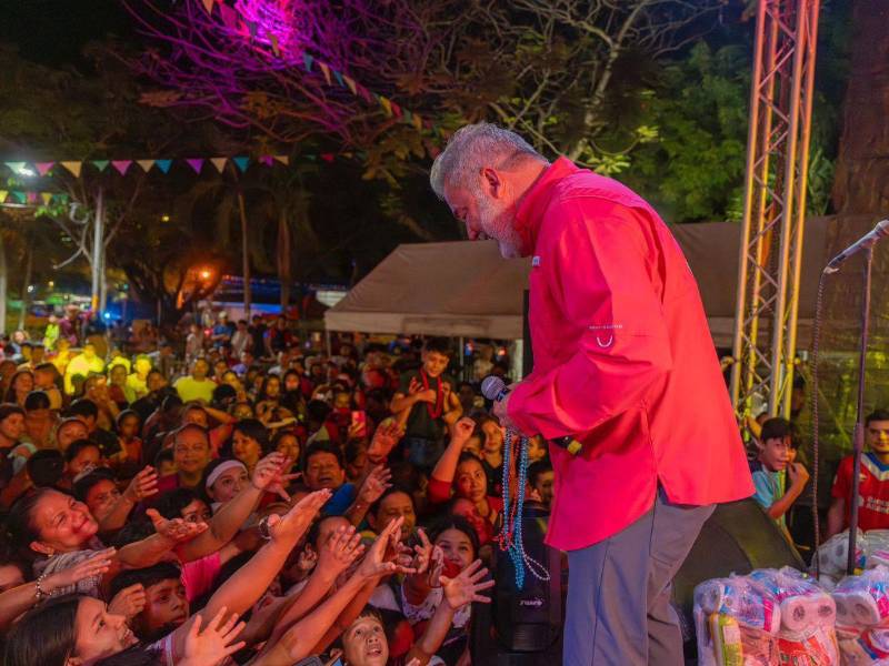 El alcalde Roberto Contreras regalando collares a los presentes en los carnavalitos, además de otros regalos.
