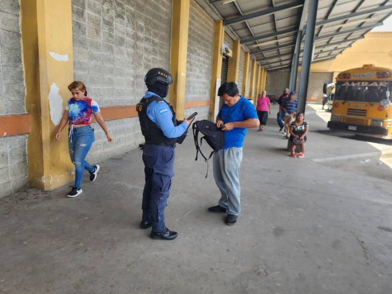 Un agente de seguridad tomando los datos personales de de un viajero en la Terminal de la ciudad.