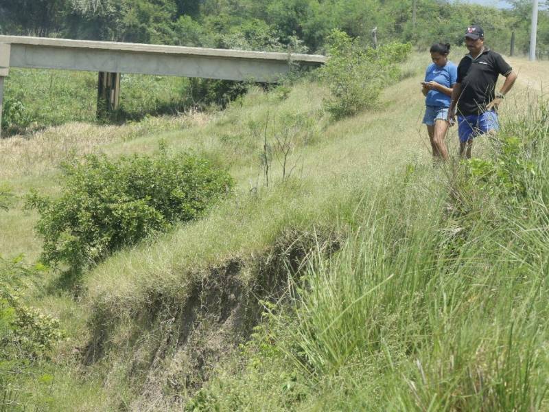 Mirna Membreño y Rolando Castellanos, habitantes de la colonia San José de La Lima, Cortés, observan los daños del canal Marimba.