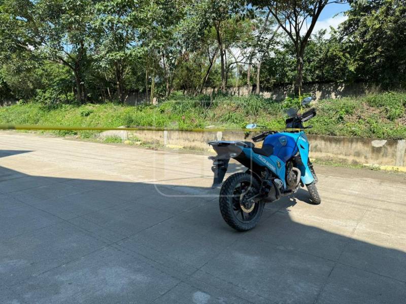Motocicleta de la Policía Nacional permanece en la escena donde fue hallado sin vida un joven en la colonia Luisiana de San Pedro Sula.