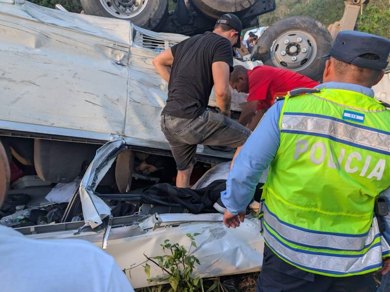 Hombres trabajan para liberar a las personas atrapadas entre los restos del bus tipo coaster.