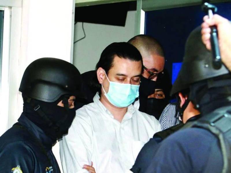 Marco Bográn, exdirector de Invest-H, es custodiado por agentes policiales.