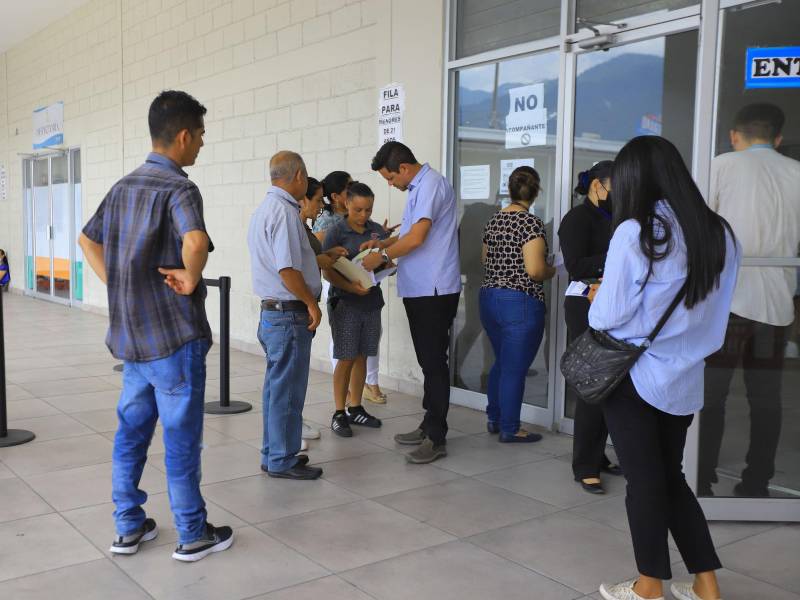 Un oficial de Migración en San Pedro Sula mientras revisaba la documentación de los familiares de los tres jóvenes de la aldea Nuevo Porvenir, Protección, Santa Bárbara, que lograron tramitar el pasaporte.