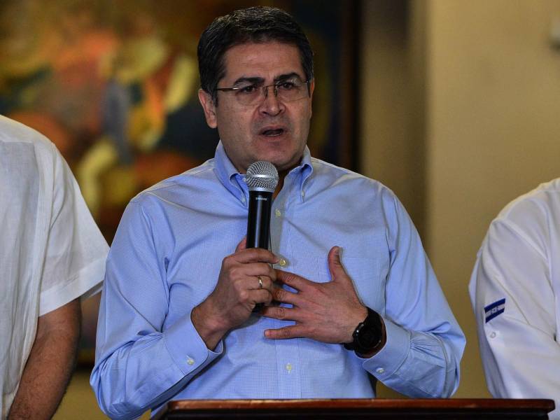El presidente hondureño, Juan Orlando Hernández (centro), ofrece una conferencia de prensa en el palacio presidencial de Tegucigalpa, el 18 de octubre de 2019.