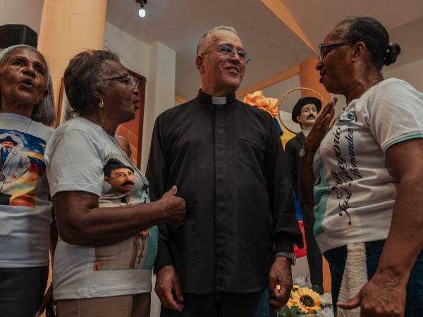 Personas haciendo fila para tomarse fotos con el padre Numa Molina tras una misa en Marizapa, Venezuela. El sacerdote ha sido paladín de los pobres.
