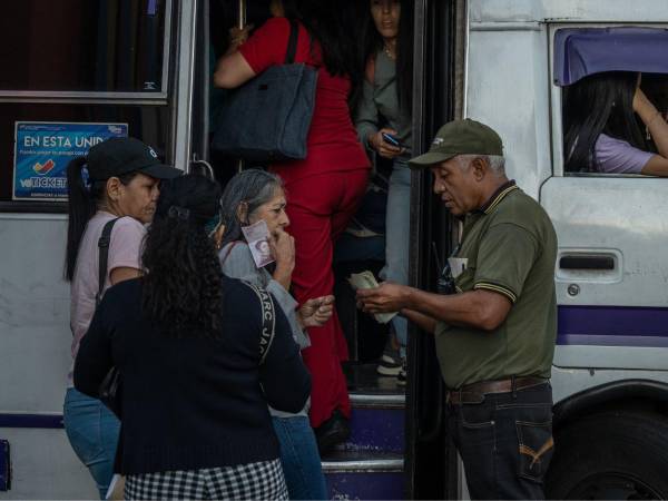 Viajeros matutinos suben a un autobús público en Caracas, Venezuela, el 13 de enero de 2026. Una encuesta de Gallup reveló que el año pasado, tres de cada cinco venezolanos tuvieron dificultades para comprar comida.