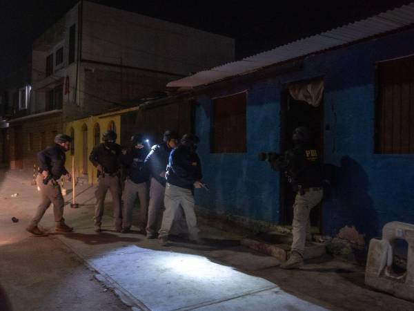 La policía chilena en una vivienda en la ciudad portuaria de Iquique durante un operativo antipandillas en noviembre.