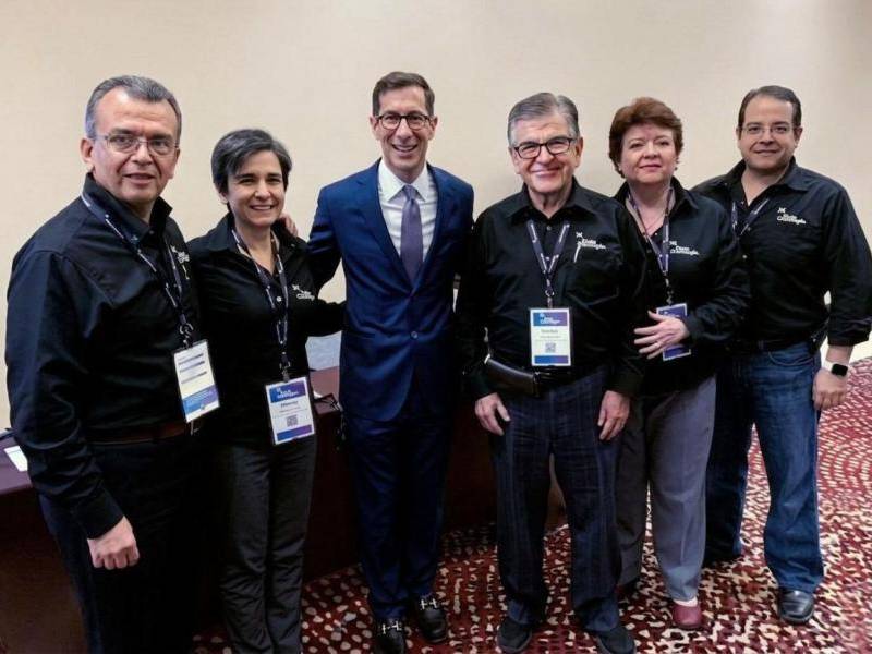 Santamaría con sus cuatro hijos y con Joe Hart, presidente mundial de Dale Carnegie, en una convención en Brasil.