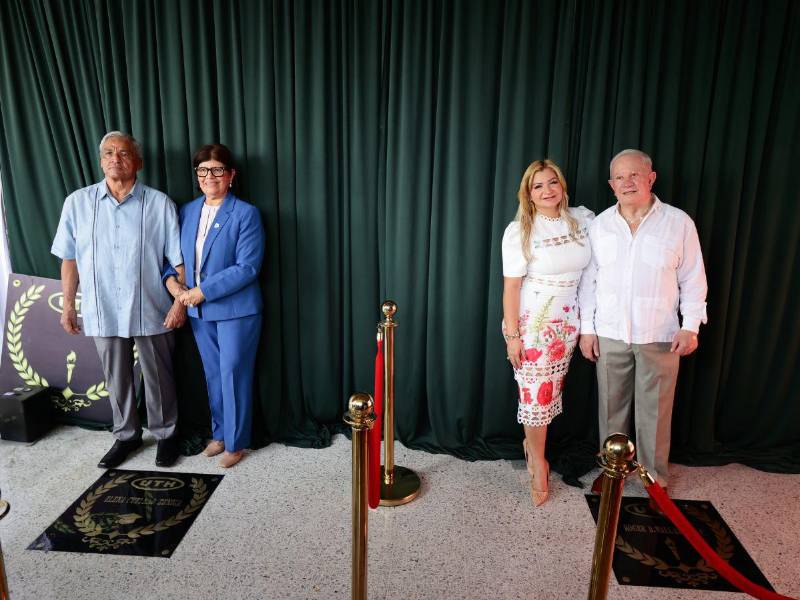 Los homenajeados juntos a sus esposos posan con orgullo al pie de sus placas de reconocimiento.