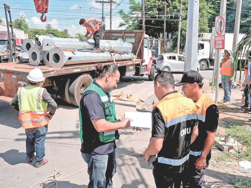 Trabajadores municipales en una de las intersecciones que requiere de reguladores de tráfico.