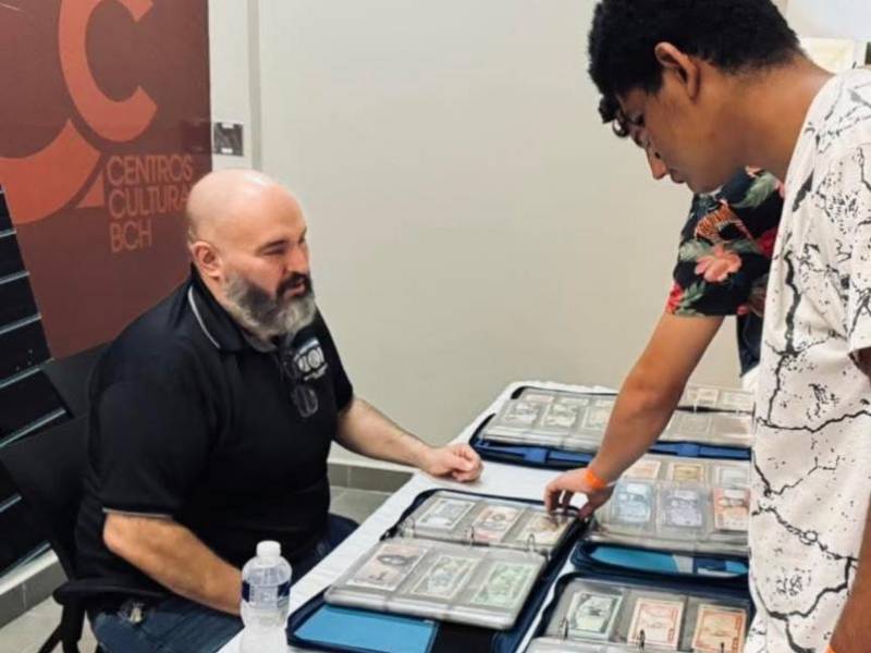 Un visitante a una exposición observa algunos de los billetes expuestos.