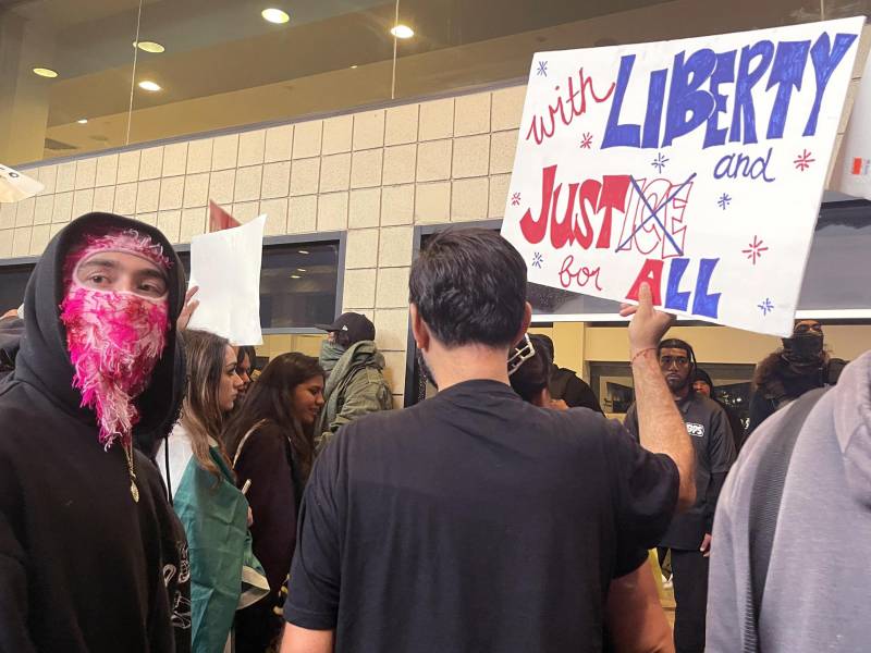 Personas protestan frente a un hotel donde se hospedan agentes del Servicio de Control de Inmigración y Aduanas (ICE).