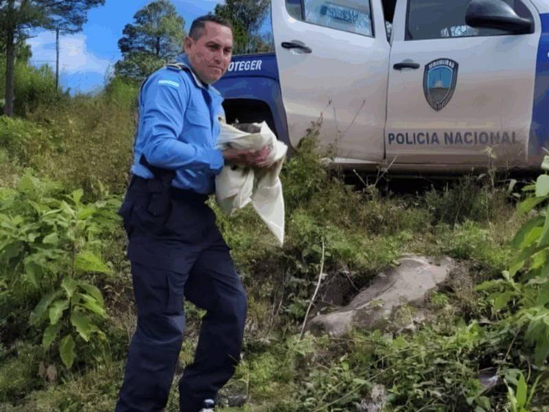 Policía sostiene al menor rescatado.