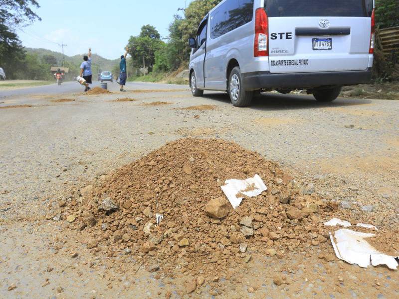 Hombres tapan los grandes baches con tierra a la altura de Cofradía, aún faltan que reparen dos tramos más las cuadrillas que contrató el Gobierno, pero los trabajos van lento, aseguran pobladores.