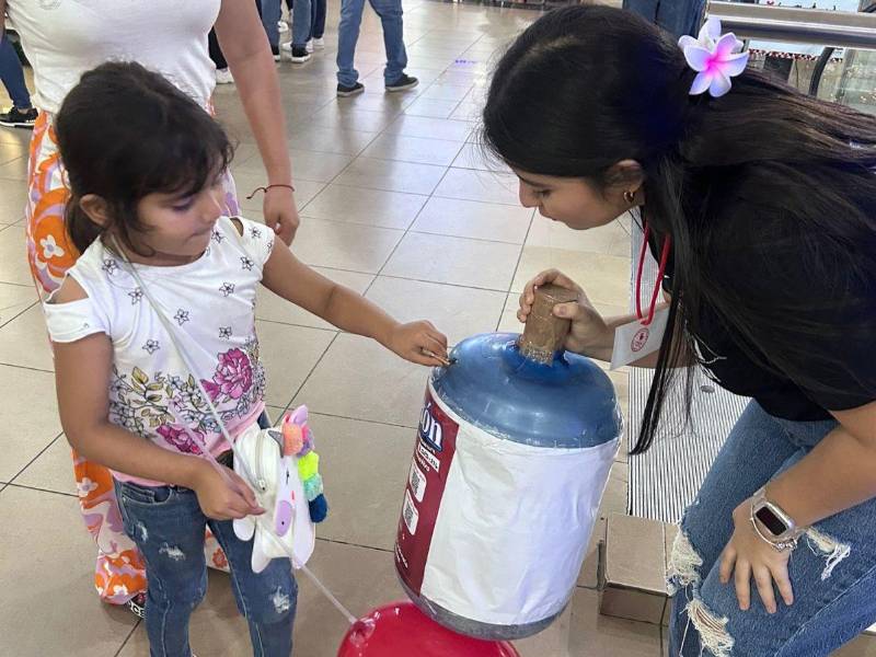 Una niña realiza su donativo en un centro comercial de San Pedro Sula.
