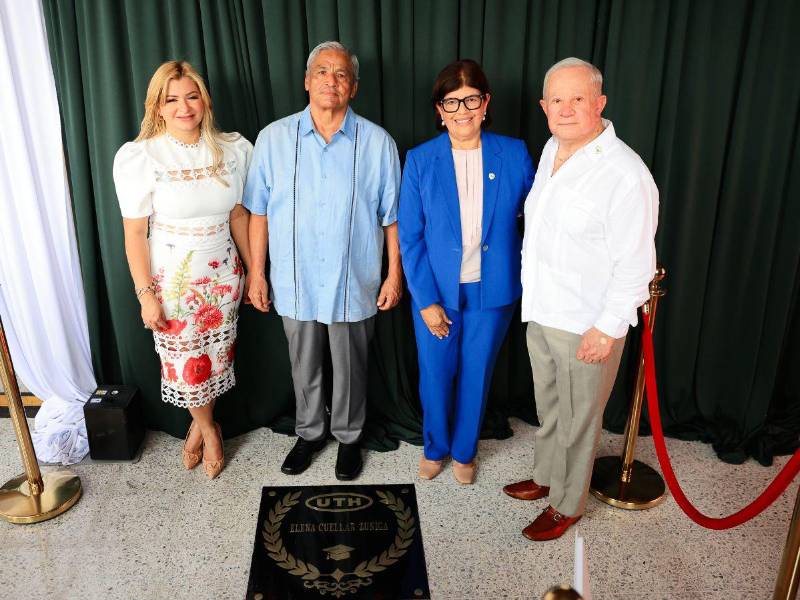 Autoridades universitarias acompañan a Elena Cuéllar durante la entrega de su reconocimiento en el Pasillo de Honor.