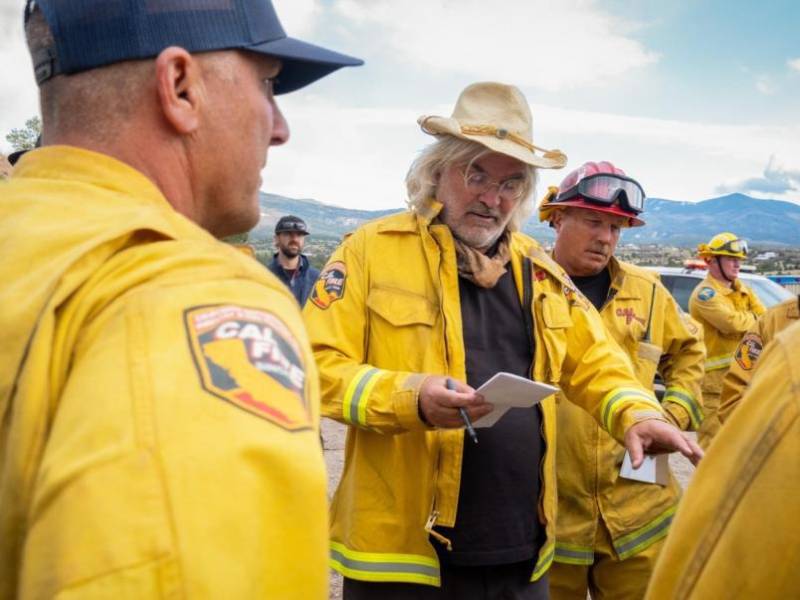 Fotografía cedida donde aparece el director de cine Paul Greengrass (c) durante el rodaje de su película 'The Lost Bus'.