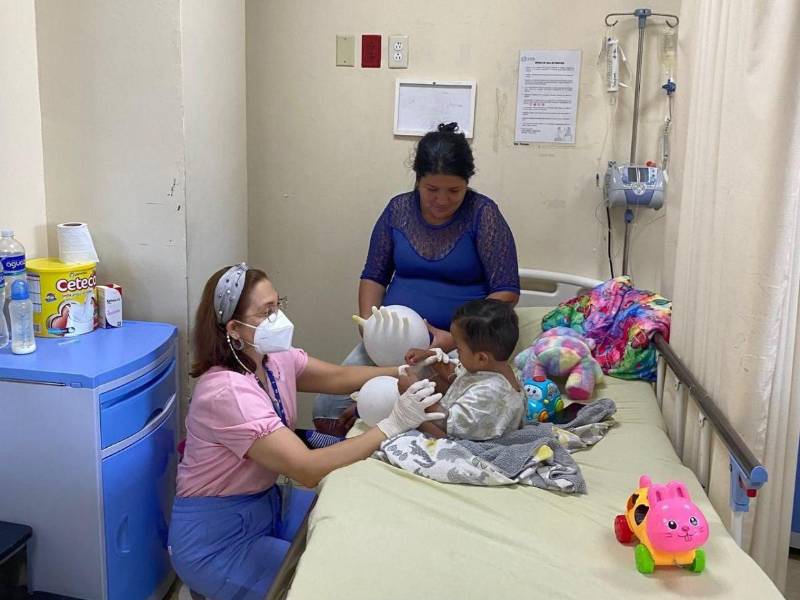 Una profesional de la salud evalúa a un niño luego de haberse sometido a una cirugía cardiovascular en la última brigada realizada en el IHSS.