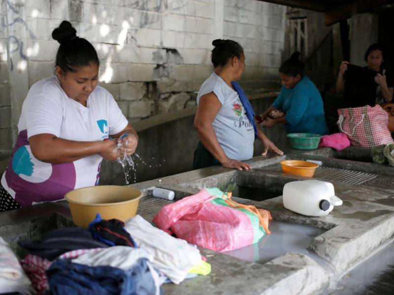 Personas utilizan agua de una reserva para lavar ropa en Tegucigalpa.