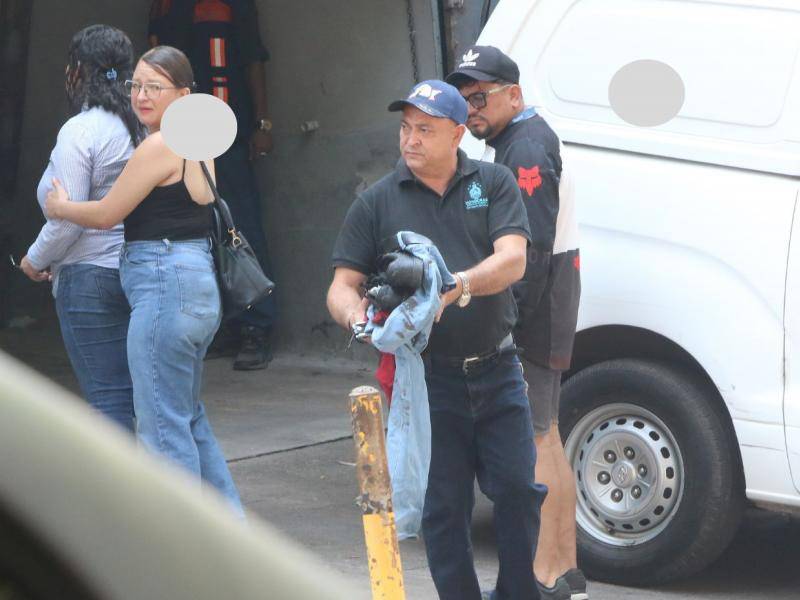 Don Samuel Juárez carga la ropa que su hijo José Manuel llevaba puesta ayer, mientras sus parientes retiran el cadáver de su vástago en la morgue.